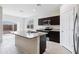 Open kitchen featuring a large island with a sink, granite countertops, stainless steel appliances, and a sliding glass door at 35569 N Breezy Ln, San Tan Valley, AZ 85140