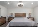Comfortable main bedroom with modern lighting, wood-look floors, and stylish wooden furniture at 4113 N 10Th Pl, Phoenix, AZ 85014