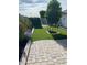 Manicured backyard features artificial grass, lush landscaping, and a stone-paved patio, perfect for outdoor enjoyment at 4432 E Carmel Ave, Mesa, AZ 85206