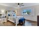 Comfortable bedroom with a decorative bed frame, ceiling fan, and natural light from the large window at 4432 E Carmel Ave, Mesa, AZ 85206