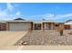 Charming single-story brick home featuring a well-maintained front yard with decorative rock and a two-car garage at 4432 E Carmel Ave, Mesa, AZ 85206