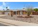 Inviting single-story home showcases xeriscaping, covered entry, and a brick facade with a two-car garage at 4432 E Carmel Ave, Mesa, AZ 85206