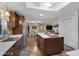 Bright kitchen with stainless steel appliances, center island with countertop seating, and an open floor plan leading to dining area at 4432 E Carmel Ave, Mesa, AZ 85206