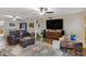 Open living room with comfortable seating, hardwood floors, large TV, and a view of the dining area at 4432 E Carmel Ave, Mesa, AZ 85206