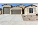 Charming single-story home with a three-car garage, manicured gravel landscaping, and neutral color palette at 4946 W Weeping Willow Way, Laveen, AZ 85339