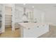 Spacious kitchen featuring a large island with quartz countertop, stainless steel hood, and white cabinetry at 4946 W Weeping Willow Way, Laveen, AZ 85339