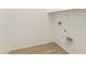 Functional laundry room featuring wood-look flooring, a storage shelf and hookups for washer and dryer at 4946 W Weeping Willow Way, Laveen, AZ 85339