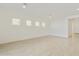 Bright, spacious living room featuring wood-look flooring, recessed lighting, and a series of windows at 4946 W Weeping Willow Way, Laveen, AZ 85339