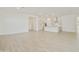 Spacious living area with light wood floors, leading into an open kitchen with white cabinets at 4946 W Weeping Willow Way, Laveen, AZ 85339
