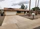 Traditional single-story home with a driveway leading to the two-car garage and front yard landscaping at 5220 E Winchcomb Dr, Scottsdale, AZ 85254