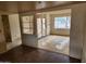 Living room showing open floor plan to front entrance, wood beam, with outdated flooring at 5220 E Winchcomb Dr, Scottsdale, AZ 85254