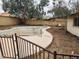 View of an empty in-ground pool surrounded by concrete and a metal security fence at 5220 E Winchcomb Dr, Scottsdale, AZ 85254