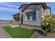 Charming single-Gathering home featuring stone accents, beautiful landscaping, and a dark brown garage at 5748 E Sierra Morena St, Mesa, AZ 85215