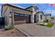 Beautiful single-Gathering home featuring stone accents, a dark brown garage, and brick paved driveway at 5748 E Sierra Morena St, Mesa, AZ 85215