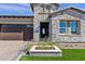 Charming single-Gathering home with stone accents, beautiful landscaping, and a dark brown garage at 5748 E Sierra Morena St, Mesa, AZ 85215