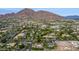 Expansive aerial view of a neighborhood with lush landscaping, pools, and a striking mountain backdrop at 5801 E Exeter Blvd, Phoenix, AZ 85018