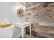 Charming bathroom with a rustic wood accent wall, pedestal sink, and decorative mirror at 5801 E Exeter Blvd, Phoenix, AZ 85018