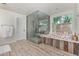 Spa-like bathroom with a walk-in glass shower, soaking tub, elegant fixtures, and plank tile flooring at 5801 E Exeter Blvd, Phoenix, AZ 85018