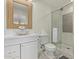 Stylish bathroom featuring a unique vessel sink, wooden framed mirror, and glass enclosed shower at 5801 E Exeter Blvd, Phoenix, AZ 85018