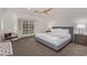 Bright bedroom featuring a ceiling fan, plush carpet, and a large window with shutter blinds at 5801 E Exeter Blvd, Phoenix, AZ 85018