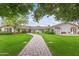 Beautiful home with lush green lawn, mature trees and stone walkway at 5801 E Exeter Blvd, Phoenix, AZ 85018