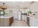 Well-lit kitchen featuring a stainless fridge, a center island, white cabinets and modern appliances at 5801 E Exeter Blvd, Phoenix, AZ 85018