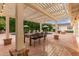 Inviting outdoor dining area under a pergola, surrounded by a lush backyard and sparkling pool at 5801 E Exeter Blvd, Phoenix, AZ 85018