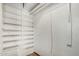 A small walk-in closet with wood-look floors, and a series of white painted shelves at 6235 N 25Th Ave, Phoenix, AZ 85015
