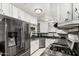 A corner kitchen featuring stainless steel appliances, white cabinets, and dark granite counters at 6235 N 25Th Ave, Phoenix, AZ 85015