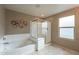 Bathroom featuring a bathtub, glass shower, tile floors, and a stylish wall decoration at 6853 E Posada Cir, Mesa, AZ 85212