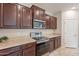 Spacious kitchen with stainless steel appliances, granite countertops, and dark wood cabinets at 6853 E Posada Cir, Mesa, AZ 85212