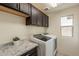 Functional laundry room with modern washer, dryer, countertop and upper cabinets at 6853 E Posada Cir, Mesa, AZ 85212