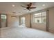 Spacious living room featuring carpet, a modern ceiling fan, and lots of natural light at 6853 E Posada Cir, Mesa, AZ 85212