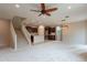 Open-concept living room with carpeted flooring, ceiling fan and adjacent kitchen area at 6853 E Posada Cir, Mesa, AZ 85212