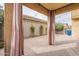 Charming covered patio with paver flooring, privacy curtains, and inviting string lights at 6853 E Posada Cir, Mesa, AZ 85212