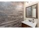 Stylish powder room with wood accent wall, modern vanity, and decorative mirror at 6853 E Posada Cir, Mesa, AZ 85212