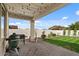 Back patio with an outdoor grill and a well-manicured lawn surrounded by a white wall at 730 W Wind Cave Dr, San Tan Valley, AZ 85140
