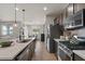 Stylish kitchen with stainless appliances, a large island, and a view into the dining and living areas at 730 W Wind Cave Dr, San Tan Valley, AZ 85140
