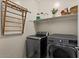 Well-equipped laundry room with modern washer and dryer, shelving, and drying rack at 730 W Wind Cave Dr, San Tan Valley, AZ 85140