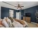 Stylish main bedroom with dark blue accent wall, canopy bed, and ensuite bathroom at 730 W Wind Cave Dr, San Tan Valley, AZ 85140