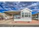 Well-maintained mobile home featuring a covered porch, carport, and low-maintenance landscaping at 7750 E Broadway Rd # 294, Mesa, AZ 85208