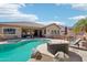 Backyard with a pool, patio, BBQ, desert landscaping and string lights at 8004 W Robin Ln, Peoria, AZ 85383