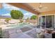 Backyard featuring a covered patio, pool, water feature, and desert landscaping at 8004 W Robin Ln, Peoria, AZ 85383