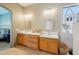 Well-lit bathroom with dual sinks, generous vanity space, and decorative hanging plants at 8004 W Robin Ln, Peoria, AZ 85383