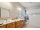 Bright bathroom features dual sinks, generous vanity space, and a glass enclosed shower at 8004 W Robin Ln, Peoria, AZ 85383