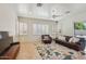 Bright living room featuring modern shutters, ceiling fan, and a comfortable leather sofa with stylish rug at 8004 W Robin Ln, Peoria, AZ 85383