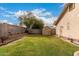 A spacious backyard with grass and planting bed, enclosed by a block wall, offering a private outdoor space at 8325 N 61St Ln, Glendale, AZ 85302