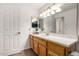 Bathroom featuring a spacious vanity with plenty of counter space, and a large, well-lit mirror at 8325 N 61St Ln, Glendale, AZ 85302