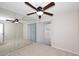 Bedroom with a ceiling fan and mirrored wall reflecting natural light at 8625 E Belleview Pl # 1012, Scottsdale, AZ 85257