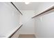 Walk-in closet featuring multiple wood shelving units and neutral carpeting at 8625 E Belleview Pl # 1012, Scottsdale, AZ 85257